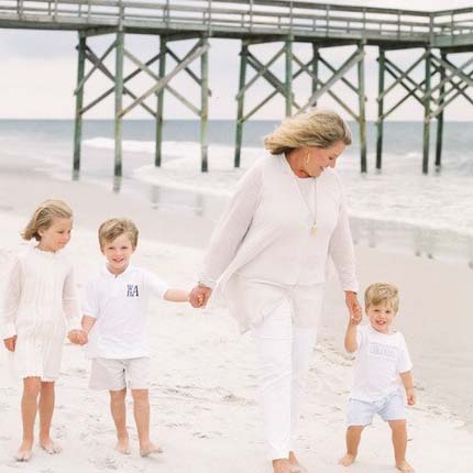 Sissy Bynum and her grandchildren hold hands on the beach