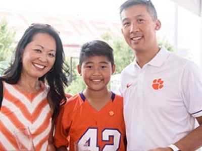 A family poses in Clemson orange at an alumni event