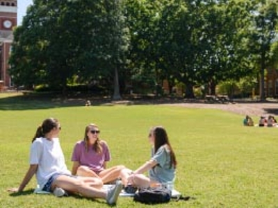Students gather in the green grass of Bowman field