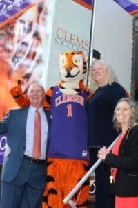 The tiger mascot sits down with a quill pen to sign a book