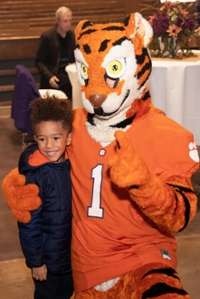 The tiger mascot hugs someone at an annual giving event