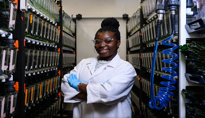 Research student standing in her work area.