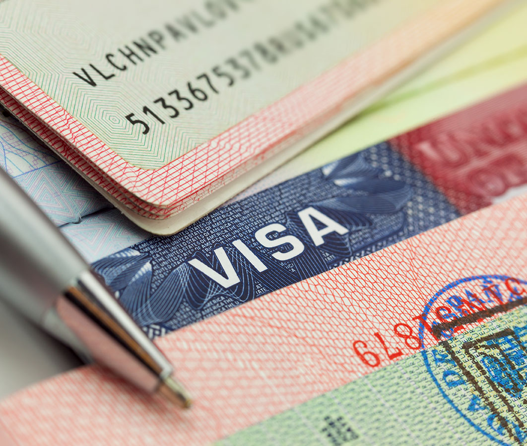 Close-up of a visa and identification documents, emphasizing the word "VISA."