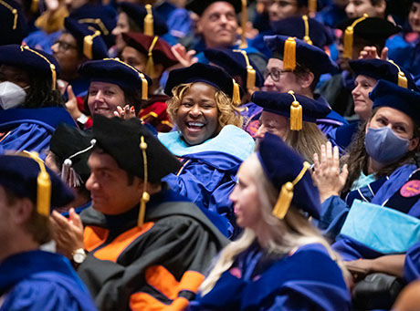 Doctoral candidate cheering in the middle of the crowd.