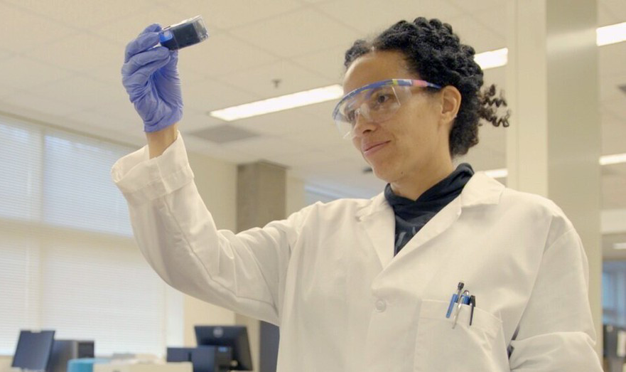 a scientist looks at a test tube in a lab setting