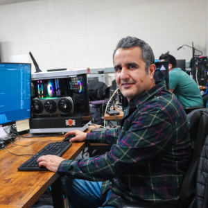 Dr. Amir Salarpour sitting at a desk with a large monitor