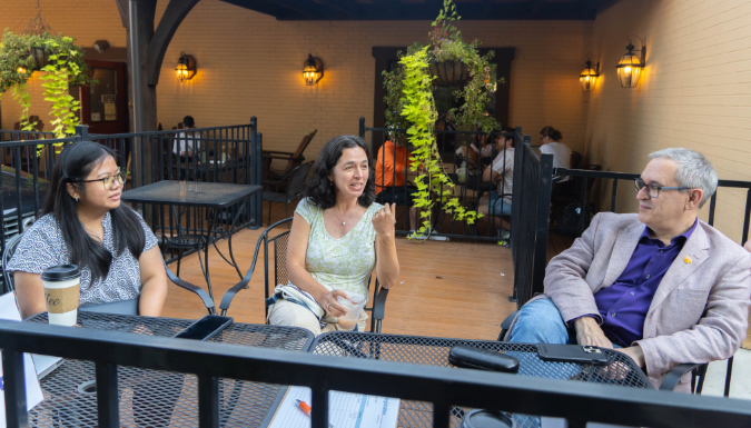 A few people sitting at a coffee shop chatting 