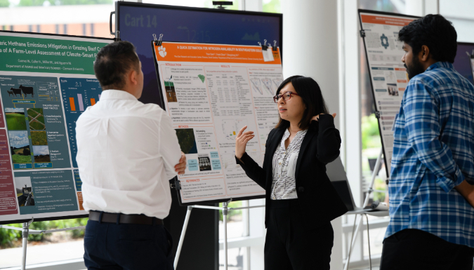 Postdoc scholar presenting their research poster to their audience 