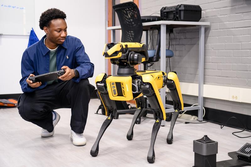 a male student in a lab with a robot