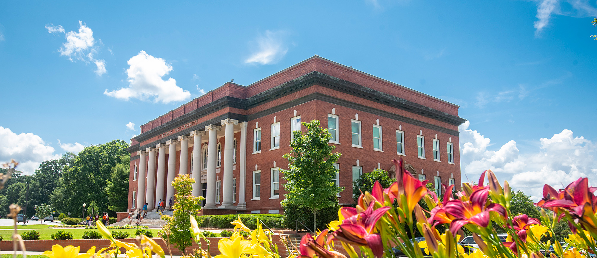 Sikes Hall on a sunny day with flowers blooming.