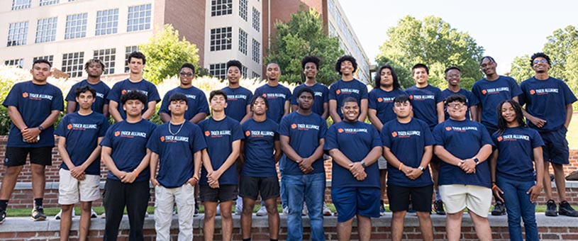 A group of students from Tiger Alliance pose outside for a photo