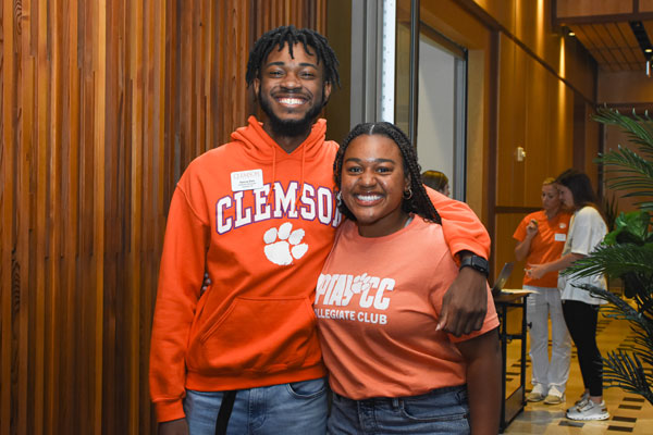 Two Clemson students pose at the entrance to experience clemson