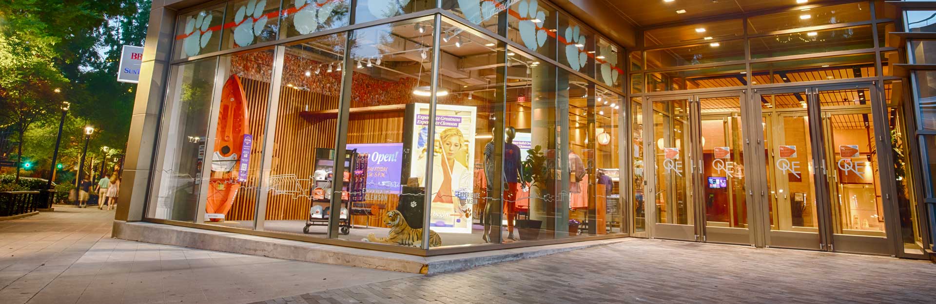 Exterior of the Clemson One building showing Clemson signage and retail products in a store window