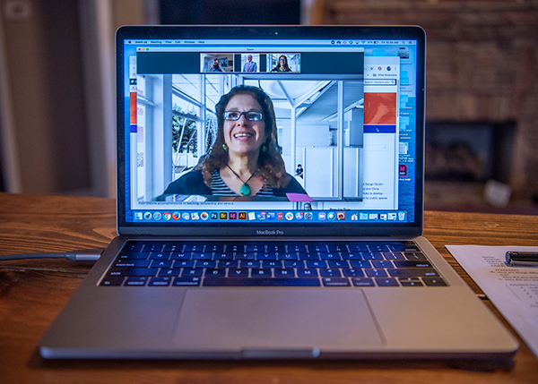 Laptop on a table with a Clemson faculty member on the screen in a Zoom meeting.