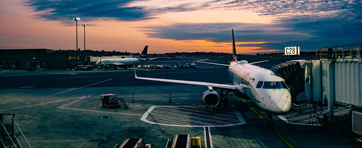 Airplane sitting in an airport terminal at sunset 