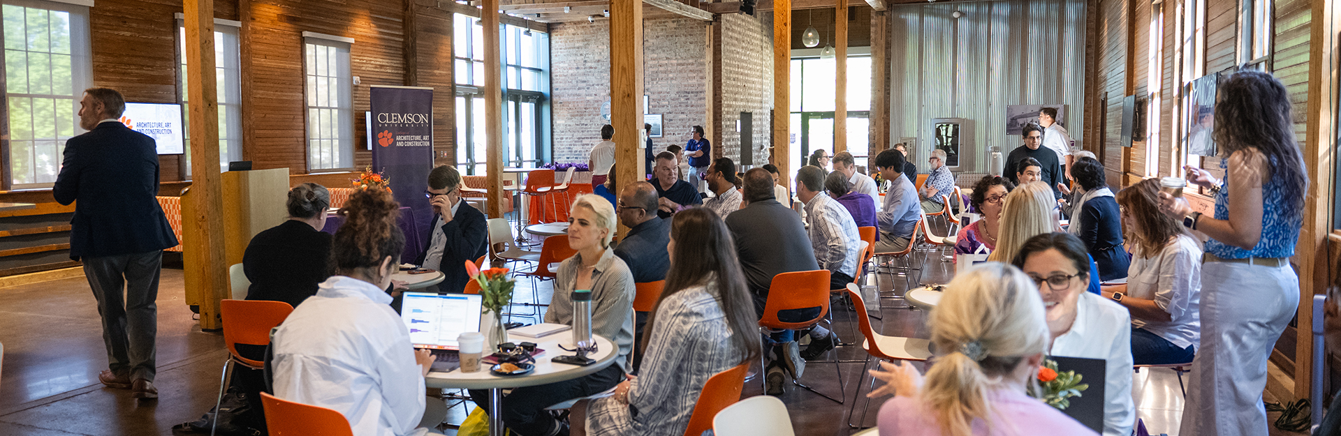 Clemson faculty members mingling at tables during the spring meeting