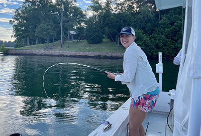 Women in Water Outdoors participant with a striped bass on the line