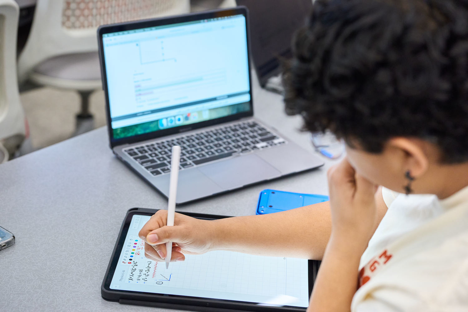 a student taking notes in a classroom
