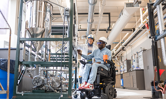 A man and a woman inside a factory building