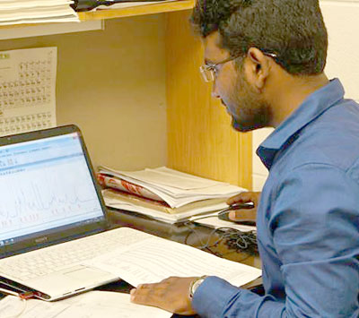 Image: DSC01419 Dr. Krishnagopal Maiti is pictured characterizing NMR spectra from compounds he has synthesized.