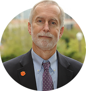 Provost Jones in a black suit jacket with an Orange Tiger Paw pin on the lapel.