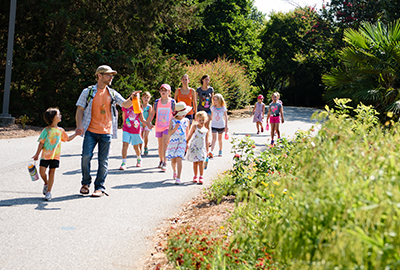 james leads a group of children on through the garden