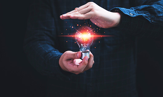 Illustrative image of a hand holding a lightbulb.