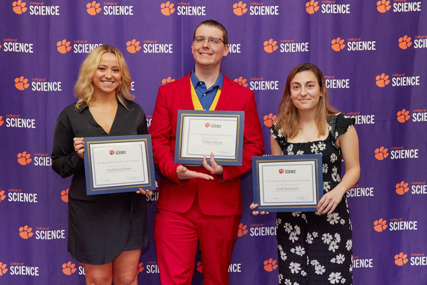 3 students holding awards.