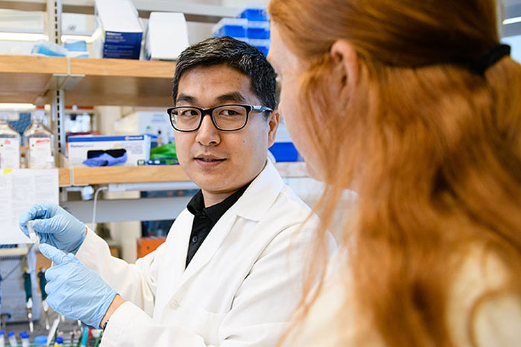 Man talking to woman in lab.