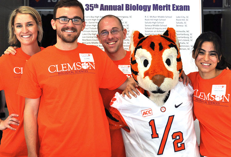 Group of students in orange shirts with Clemson Tiger mascot.