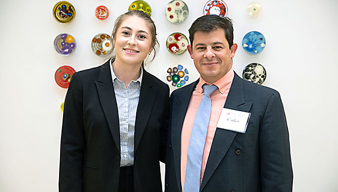 Female student (Lauren Skrajewski) with male professor (Carlos Garcia) in front of wall.