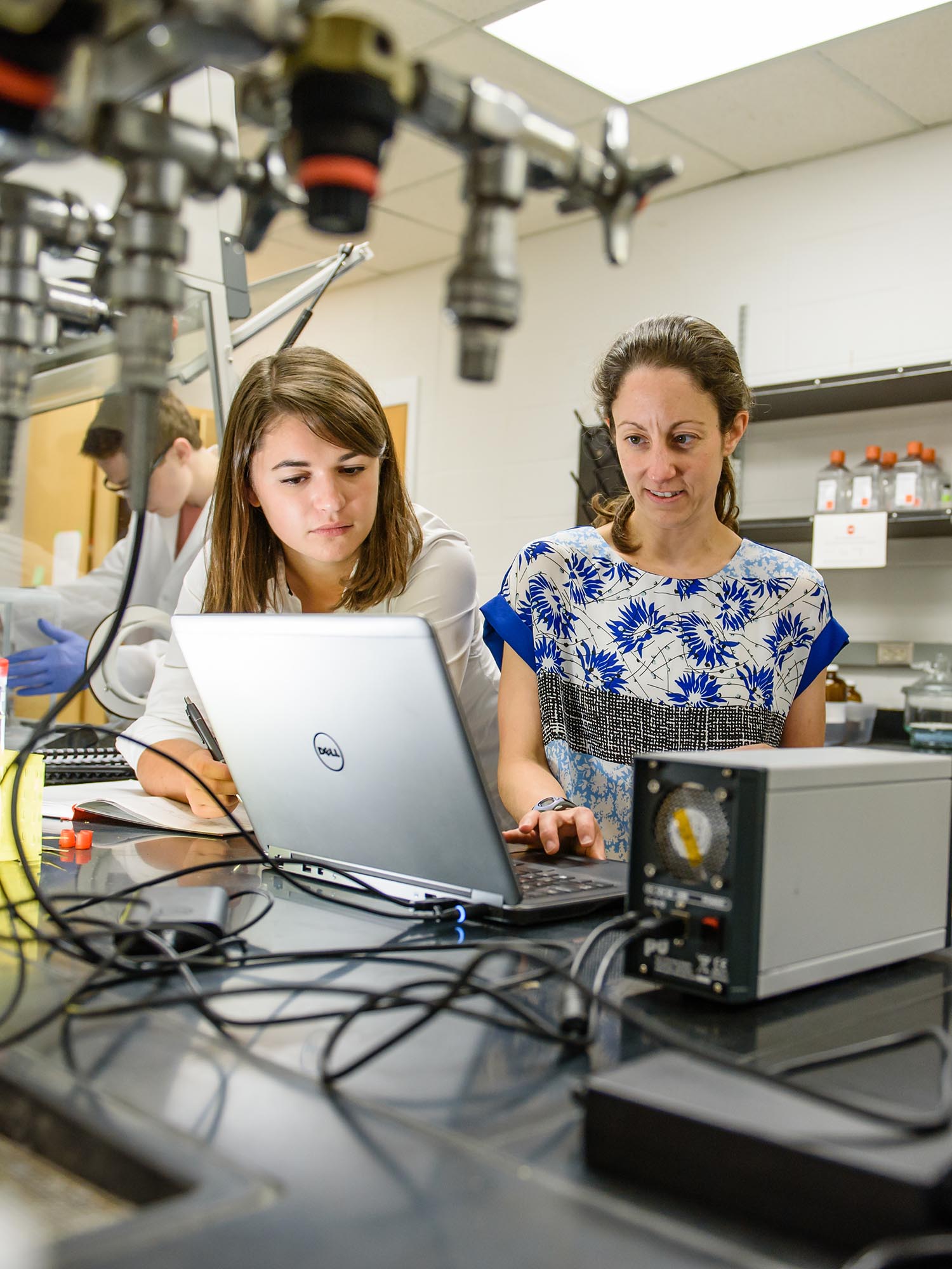 Professor with students in lab.