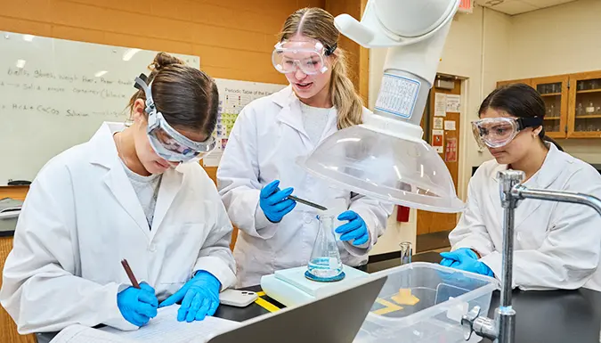 Three students working in a science lab.
