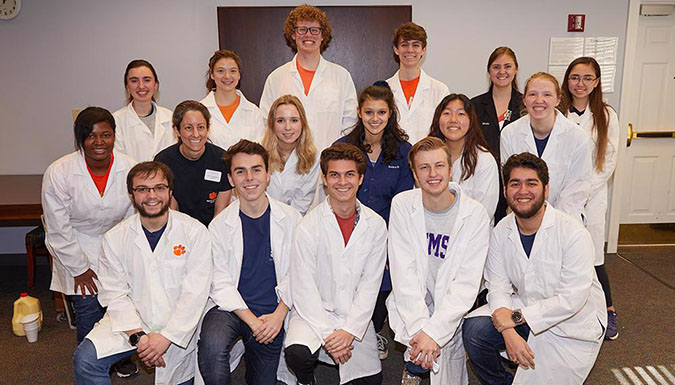 Group of people wearing white lab coats.