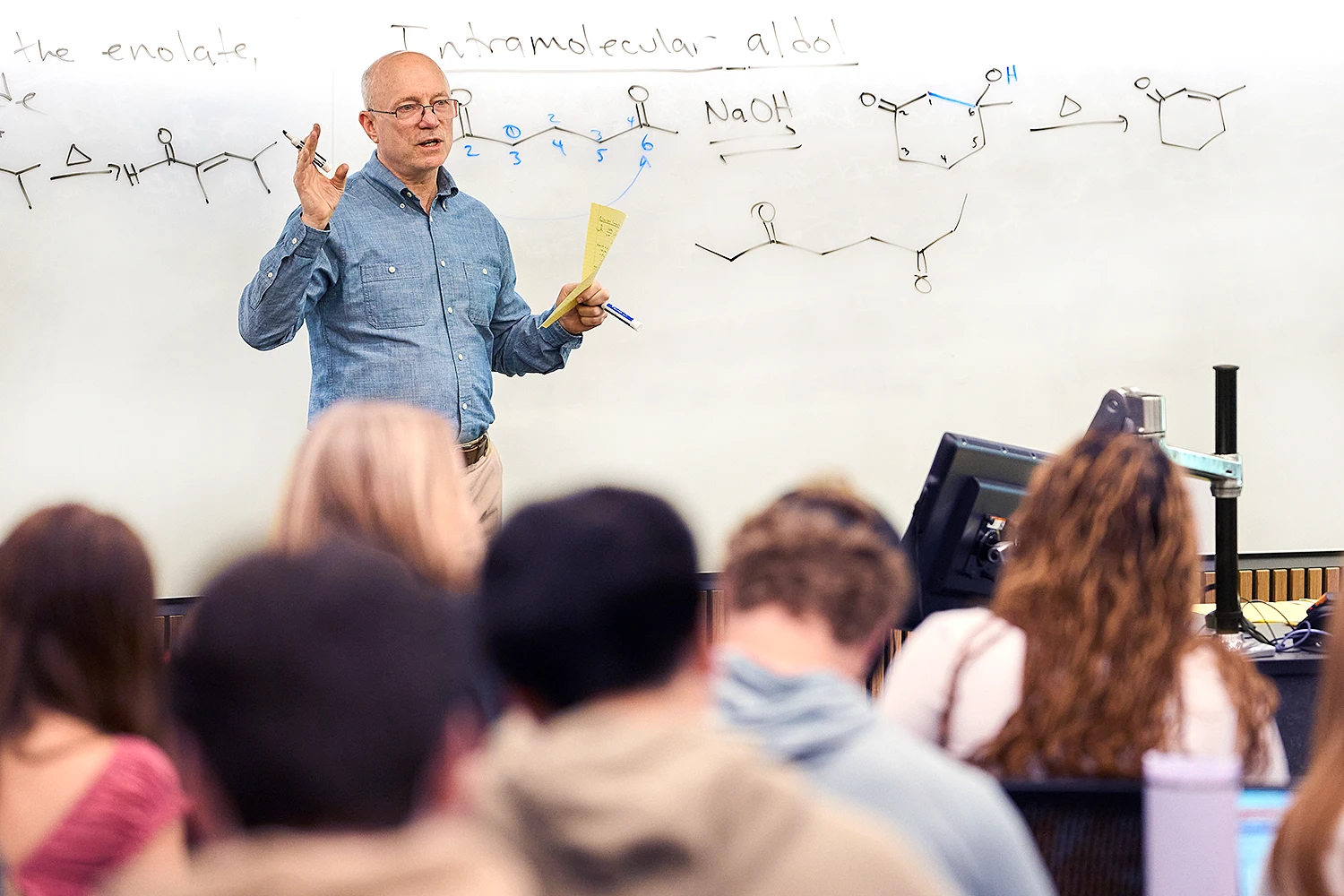 A professor lecturing to a classroom of students.