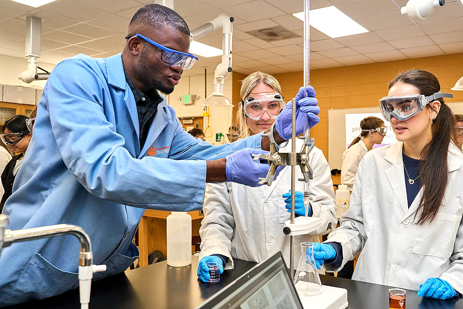Students wearing protective gear working in a lab.