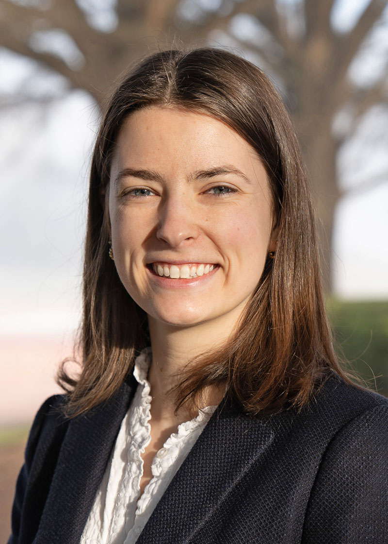 Headshot of woman, Erin Jones, with blurred nature background.