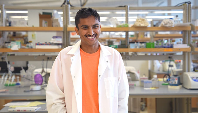Student, Gunar Sekhon, speaking in a lab, directly to the camera.
