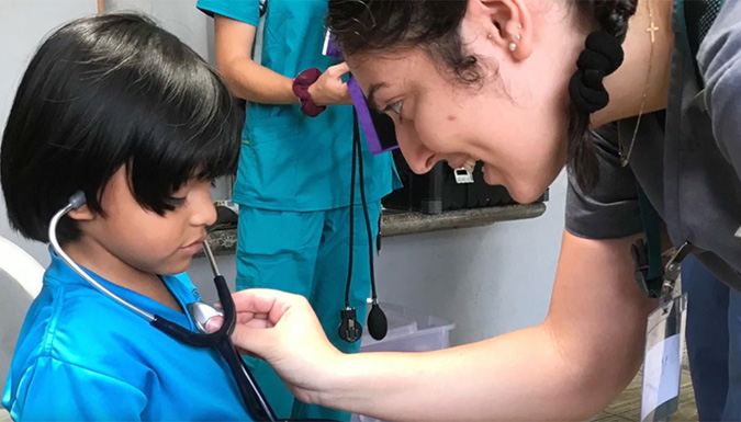 Image of student listening to child with stethoscope