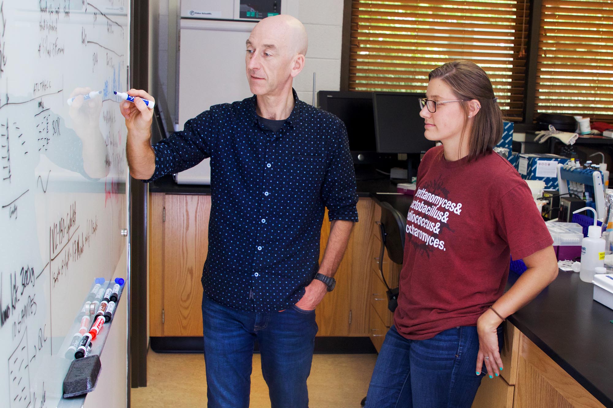 Professor, student at whiteboard in lab