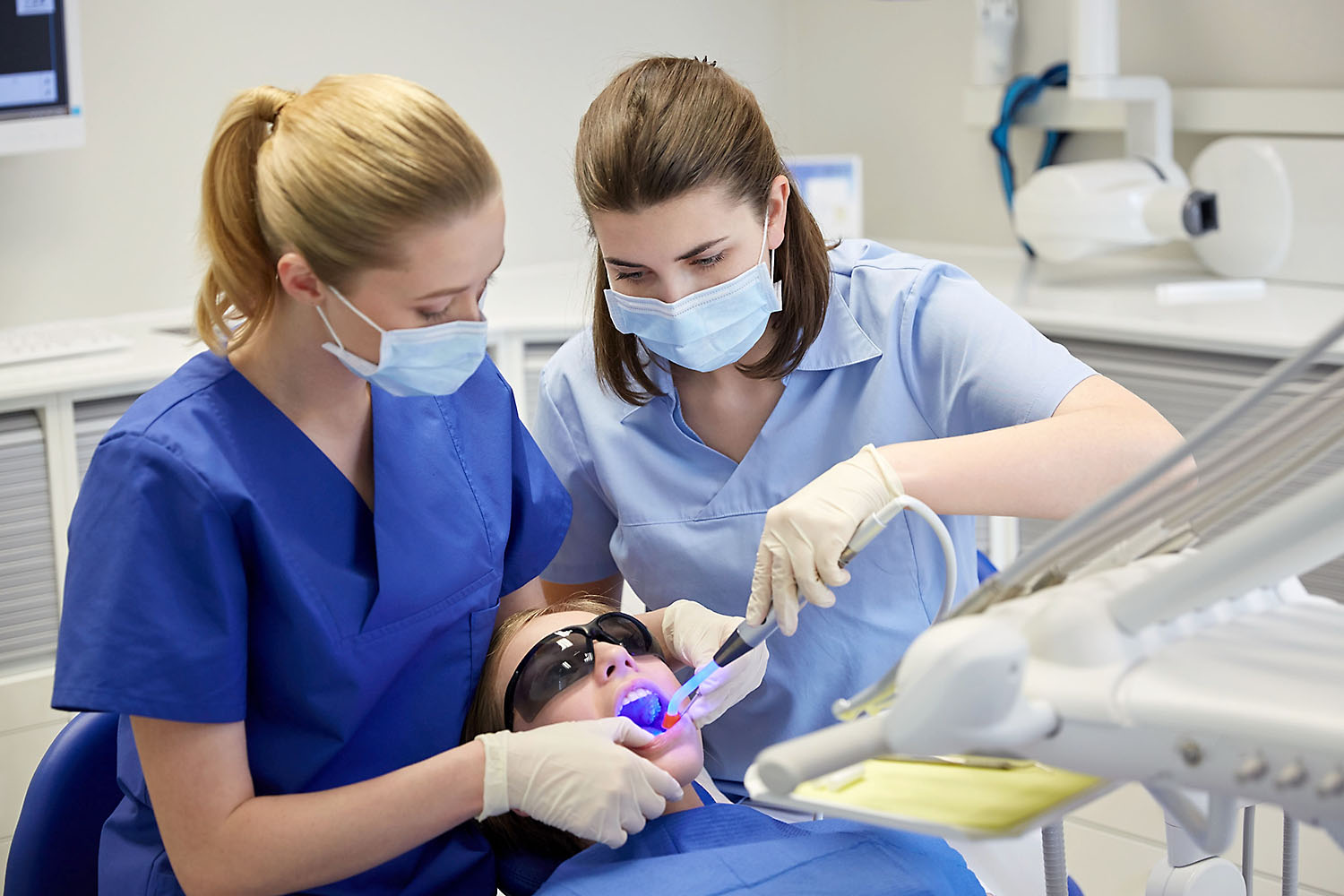 Dentist working on patient with assistant.