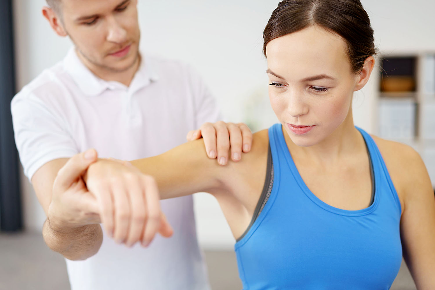 Therapist with patient holding arm.