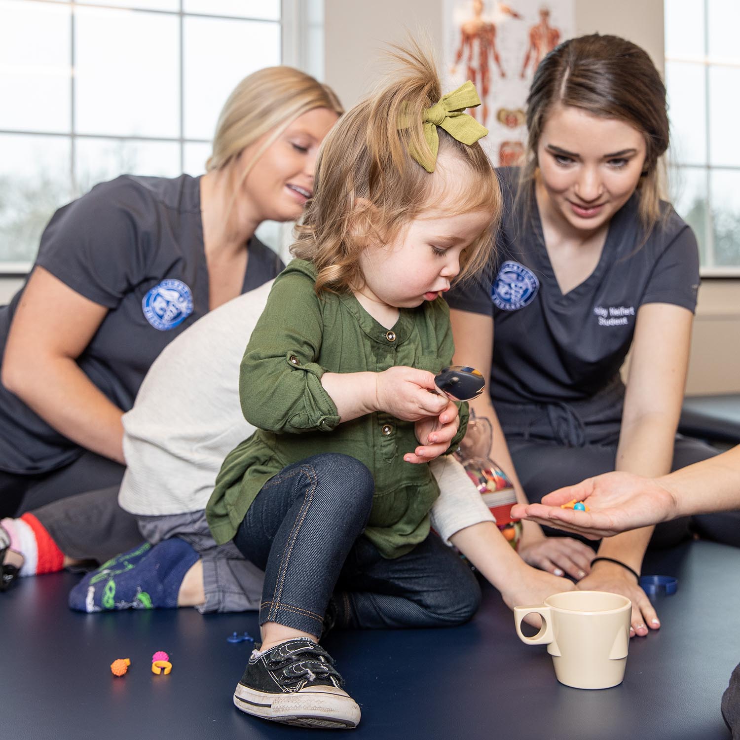 Two female college students working with a young girl.