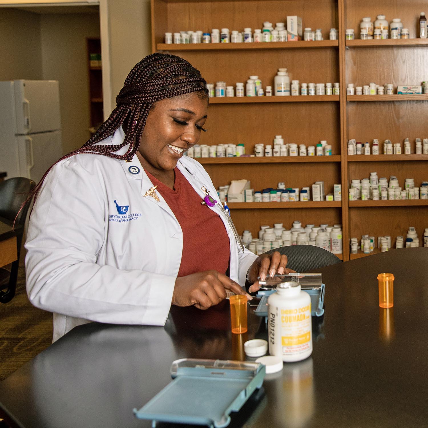 Girl working with small pills in a lab.