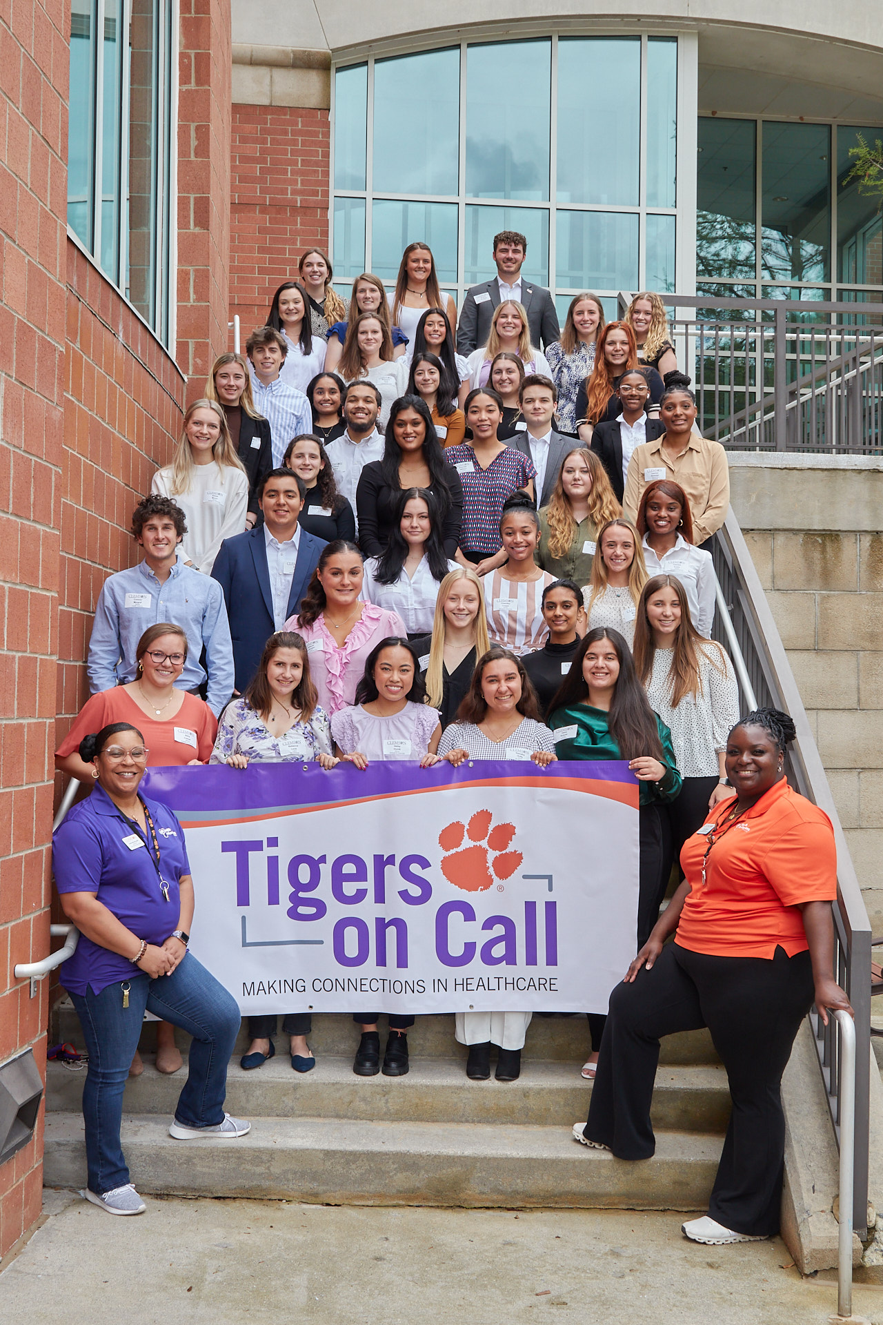 Tigers on Call/HPA students and ambassadors on steps holding a Tigers on Call banner outside Hendrix Student Center.