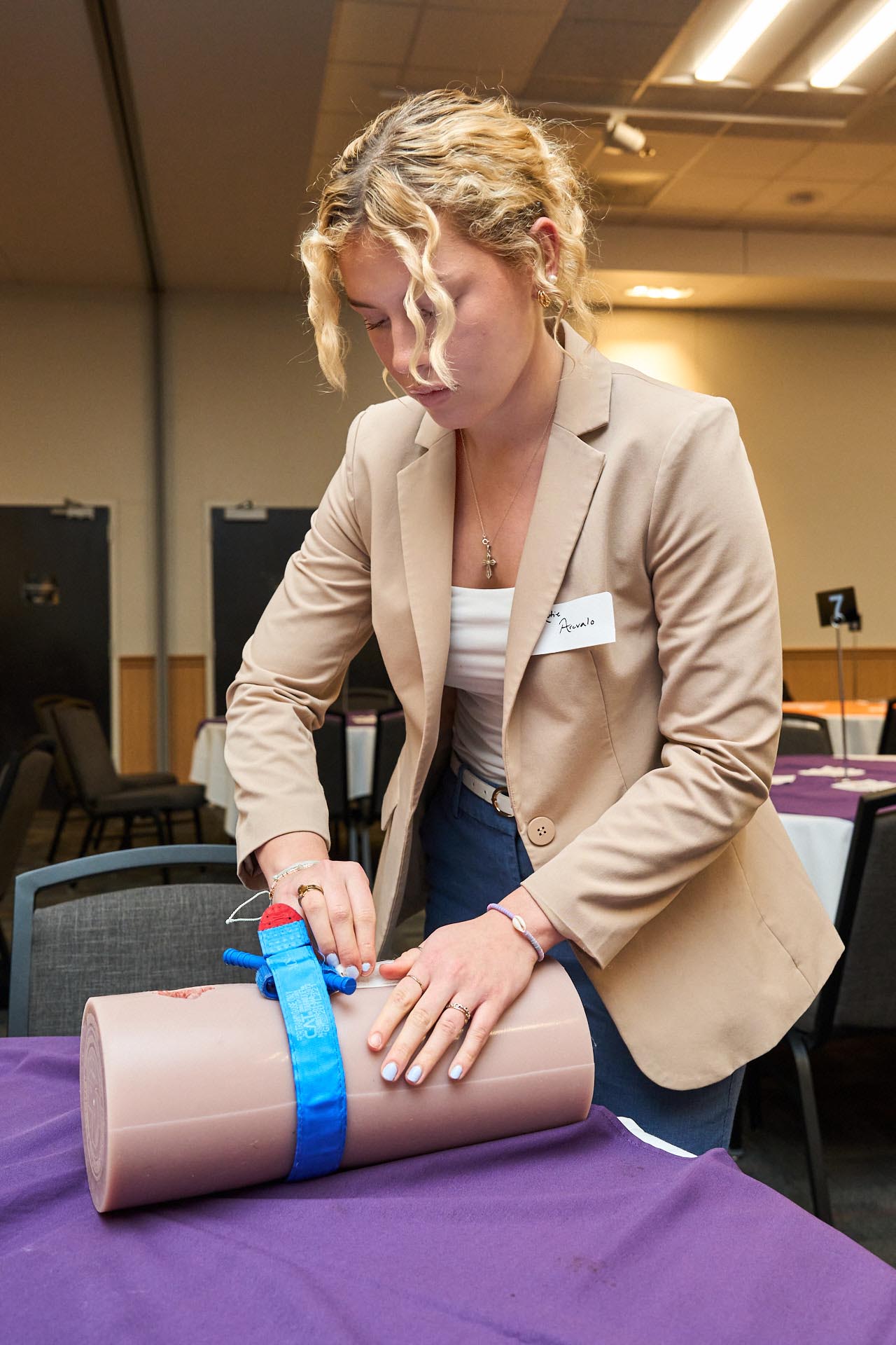 Woman practices a wound-care exercise during a medical training session.