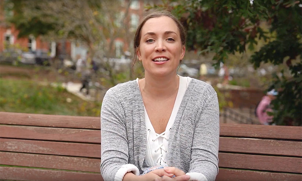 Portrait of Maddy St. Ville outside on a bench.