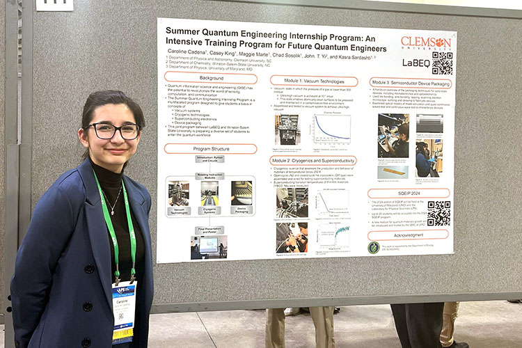 Woman standing in front of science display poster.