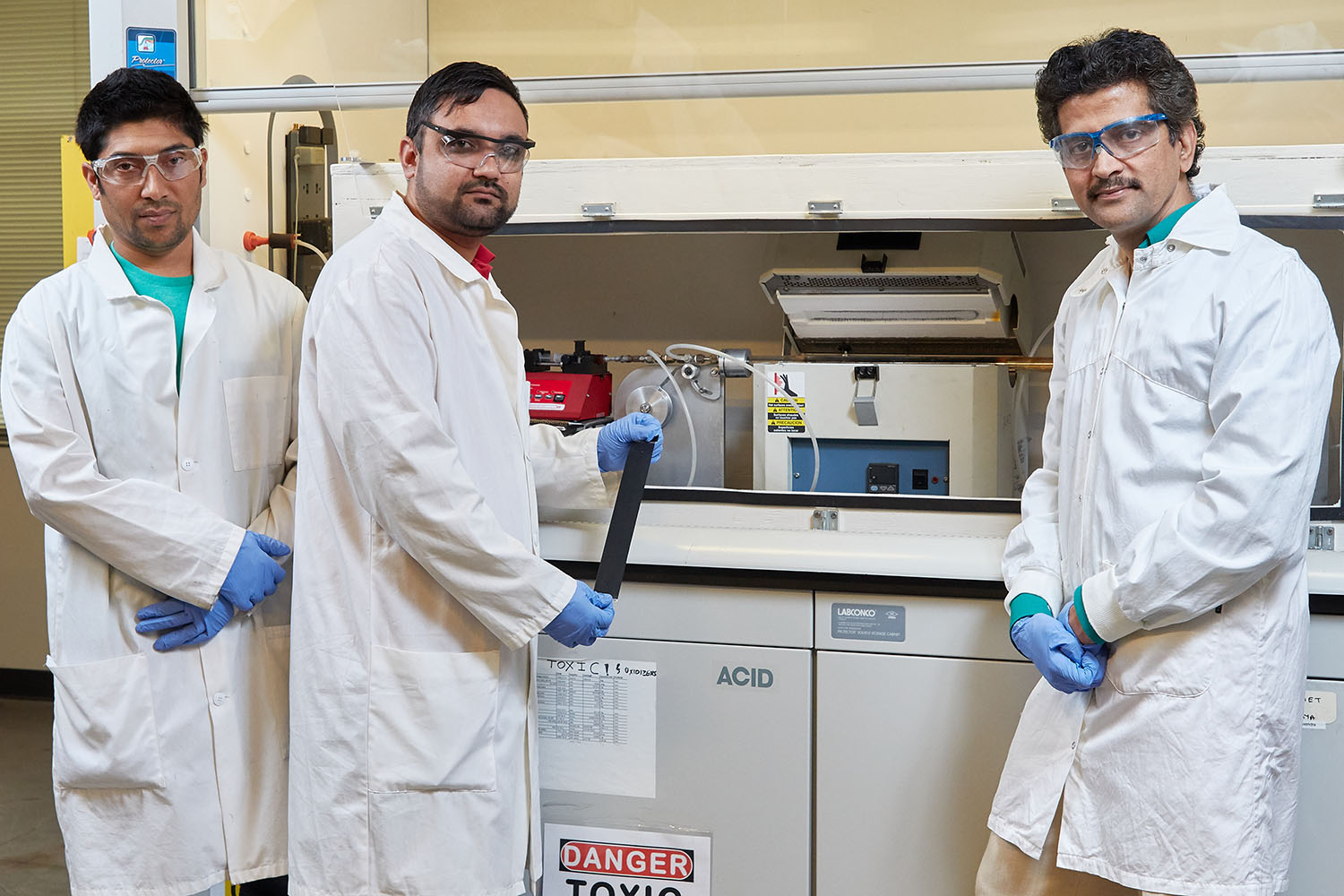 Two students and professor in lab.