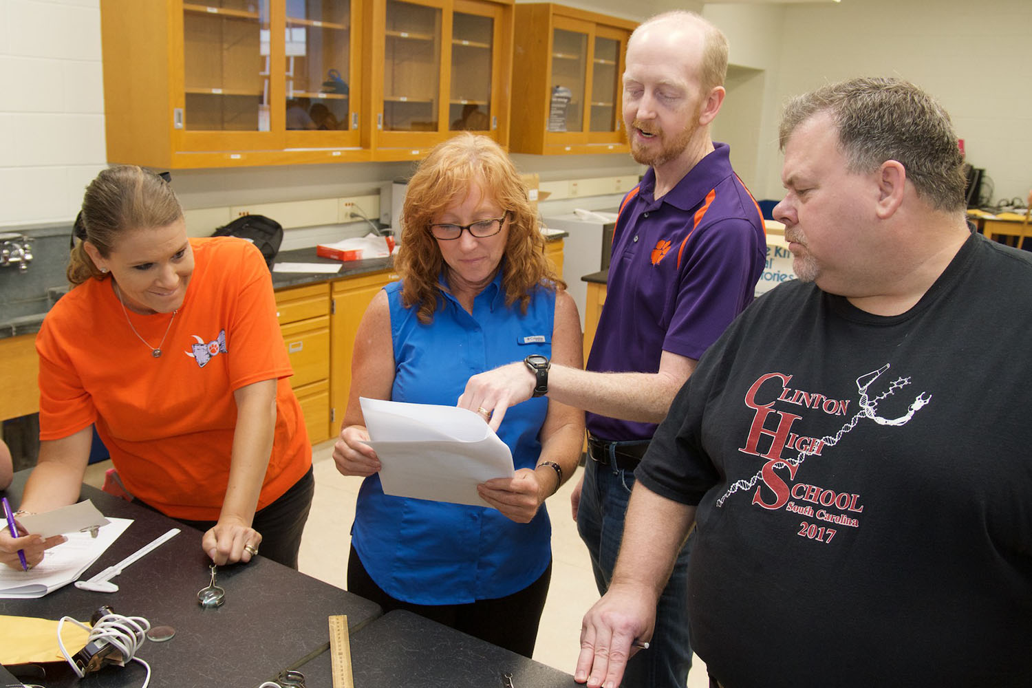 Four adults in a physics lab.